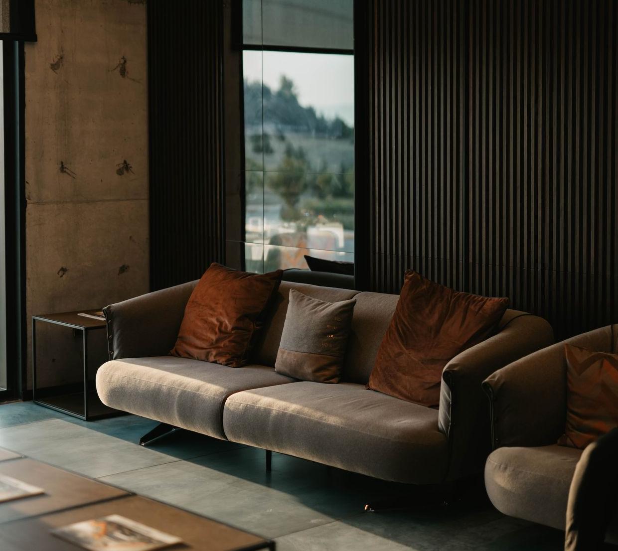 brown and white couch beside window